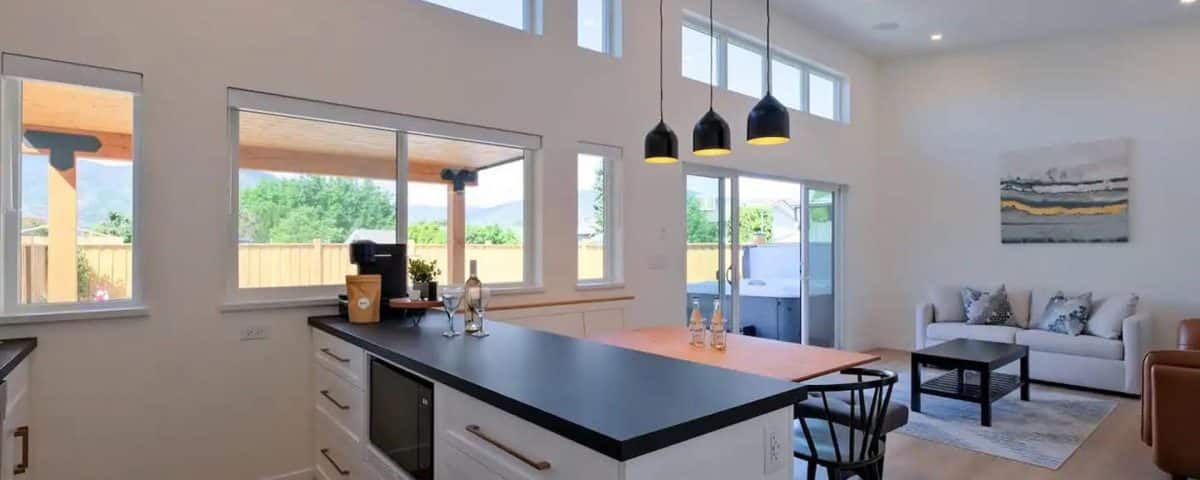 A modern kitchen and living room featuring a cozy dining area with a table and chairs, showcasing an open-concept design.