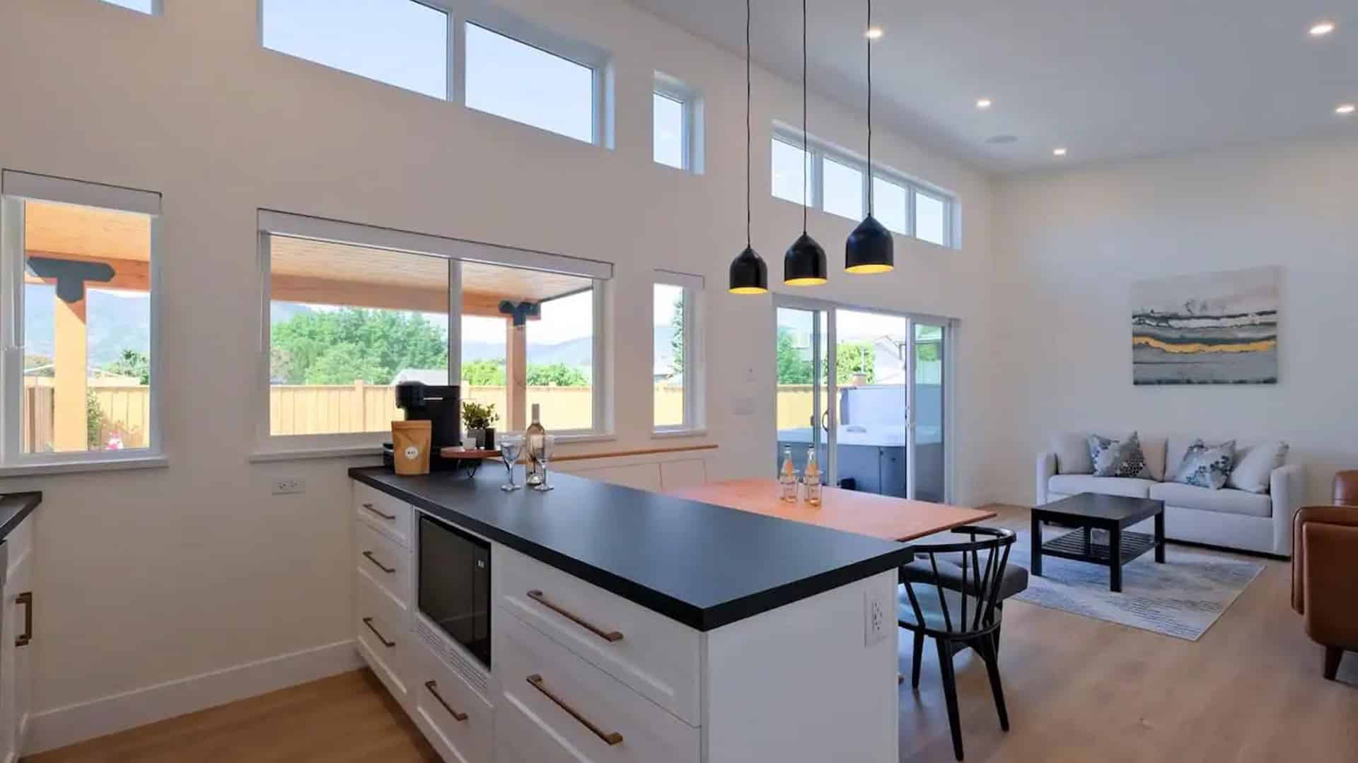 A modern kitchen and living room featuring a cozy dining area with a table and chairs, showcasing an open-concept design.