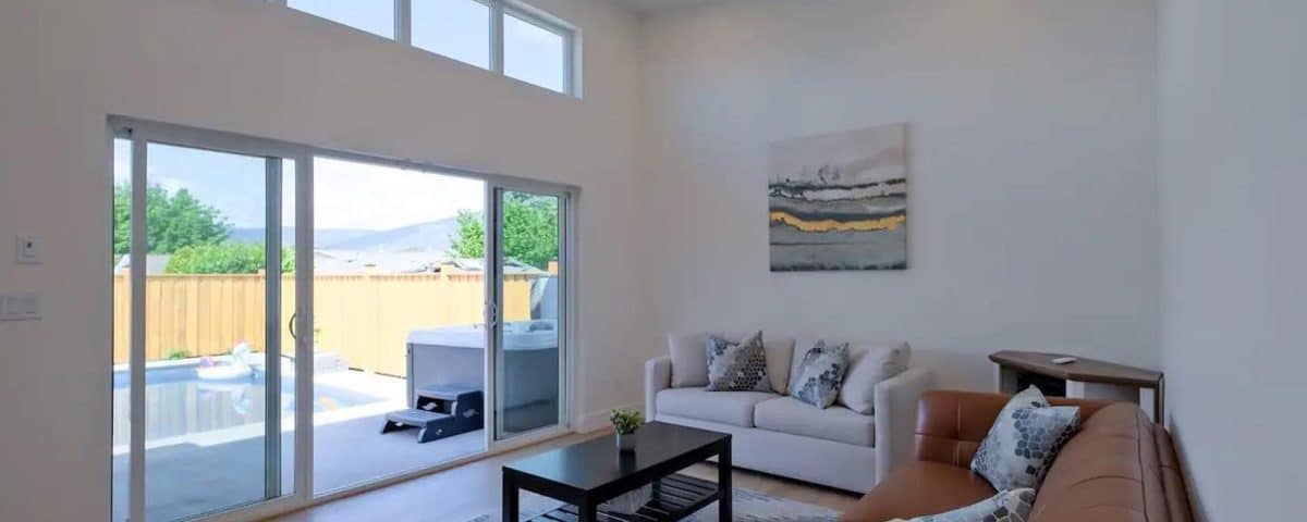 A cozy living room featuring a couch, a coffee table, and sliding glass doors that open to an outdoor space.