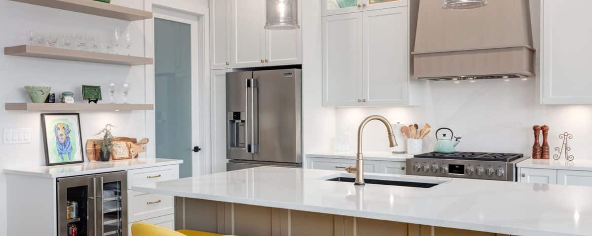 A modern kitchen featuring yellow stools and sleek white cabinets, creating a bright and inviting atmosphere.