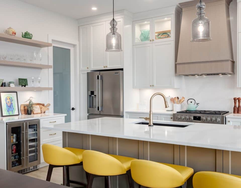 A modern kitchen featuring yellow stools and sleek white cabinets, creating a bright and inviting atmosphere.