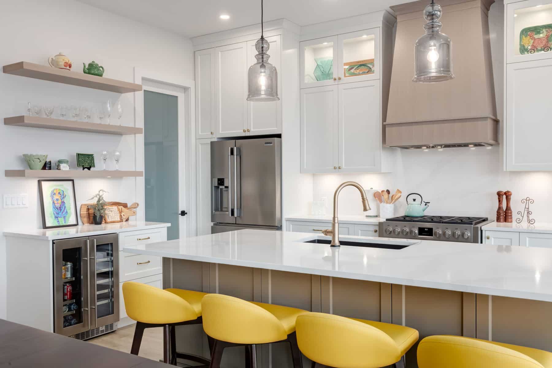 A modern kitchen featuring yellow stools and sleek white cabinets, creating a bright and inviting atmosphere.