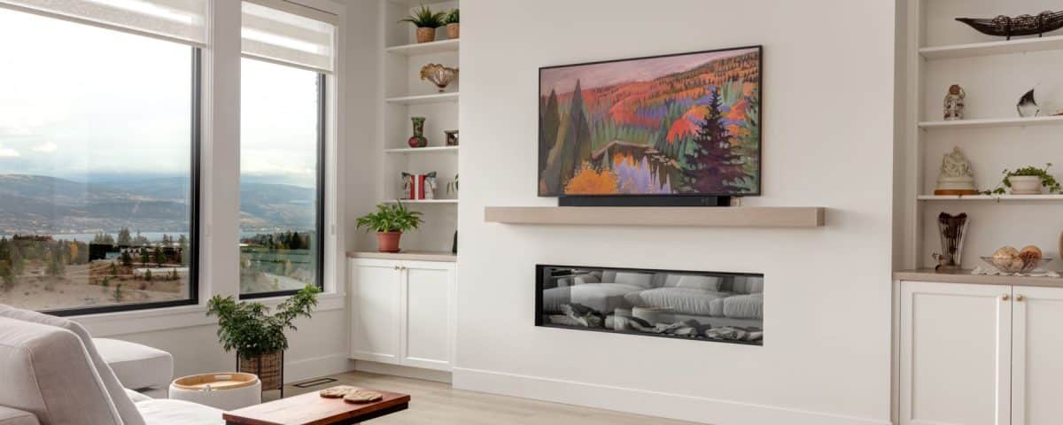 A cozy living room featuring a large flat screen TV mounted on the wall and a warm fireplace, creating a welcoming atmosphere