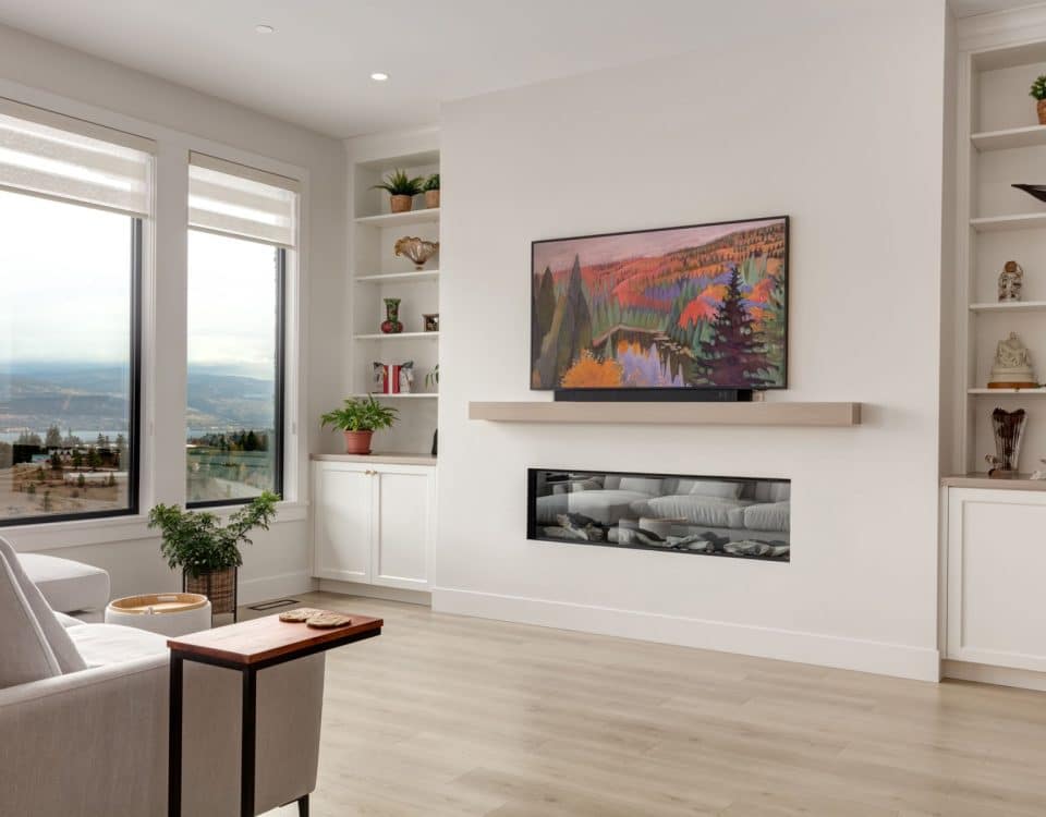 A cozy living room featuring a large flat screen TV mounted on the wall and a warm fireplace, creating a welcoming atmosphere