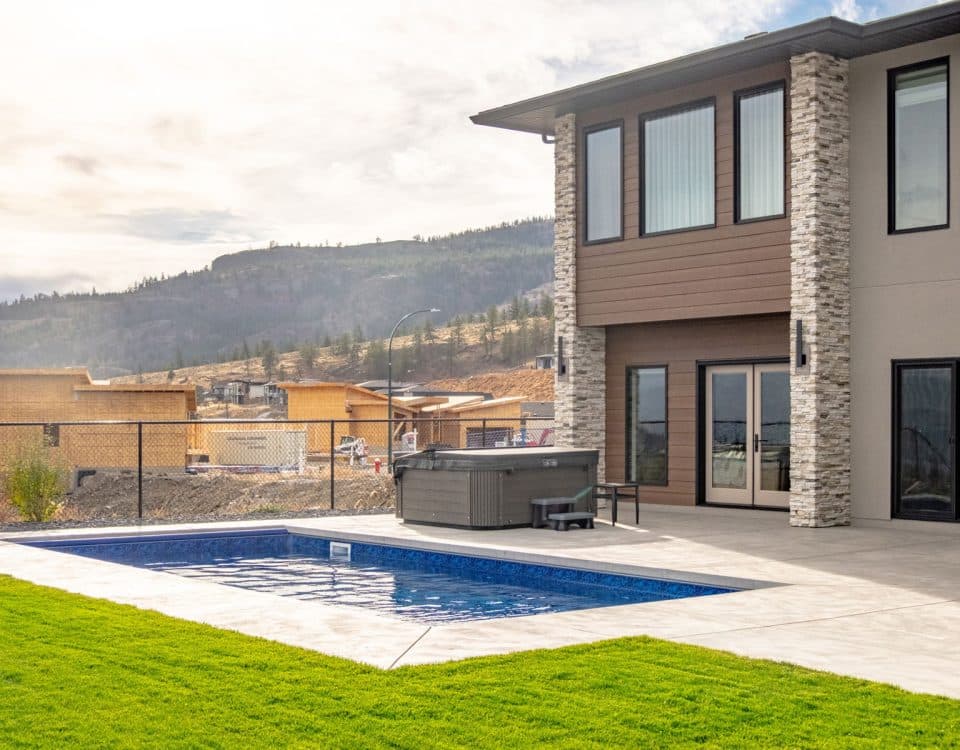 A house with a pool overlooking a scenic mountain view, showcasing a tranquil outdoor living space.