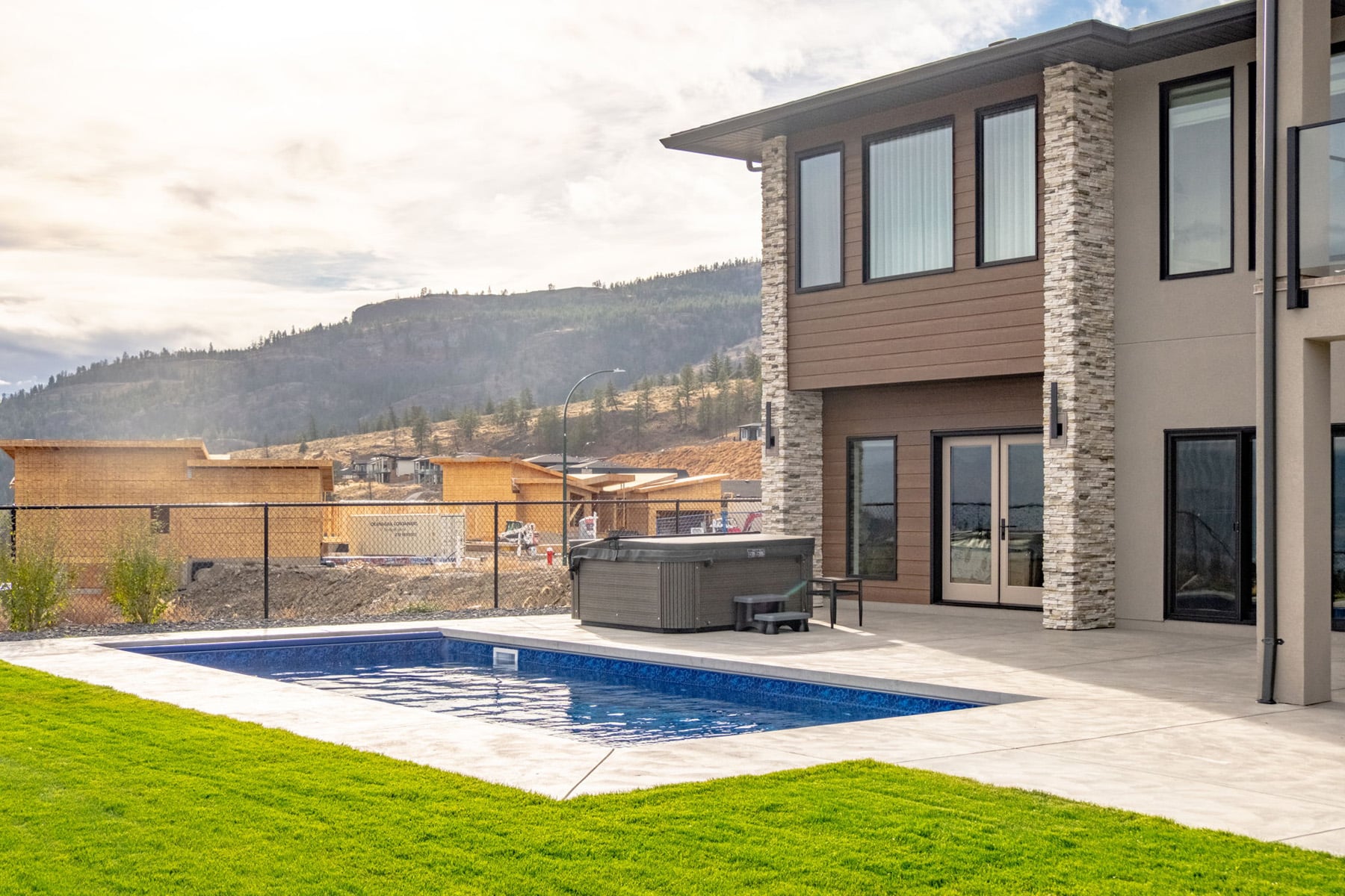 A house with a pool overlooking a scenic mountain view, showcasing a tranquil outdoor living space.