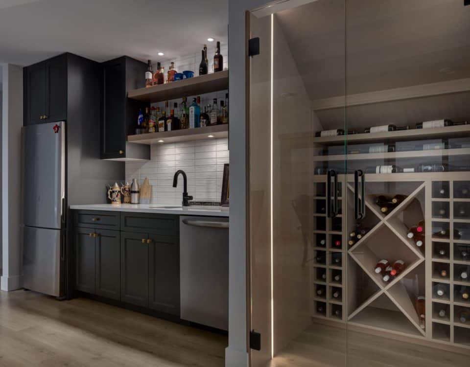 A home wine cellar featuring a refrigerator and a wooden wine rack filled with various bottles of wine.