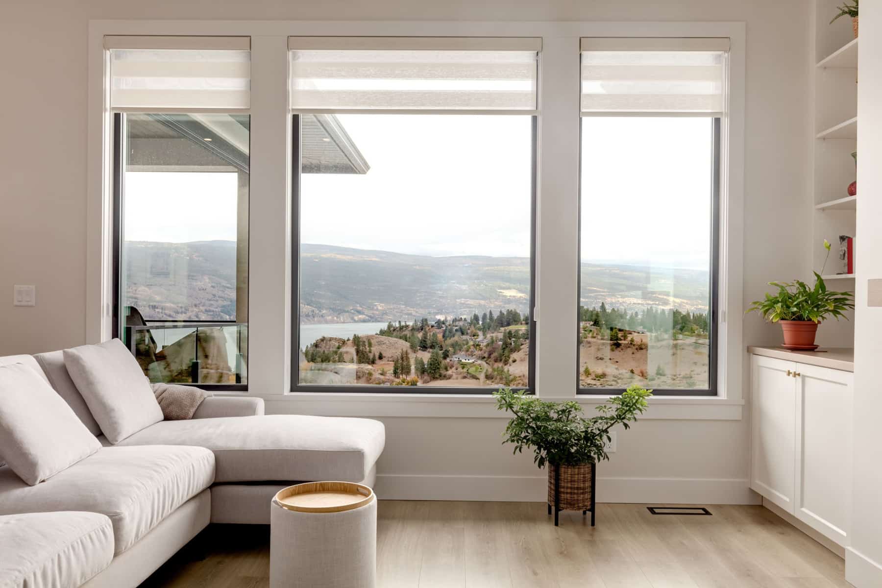 A cozy living room featuring a couch and large windows that provide a view of the serene lake outside.