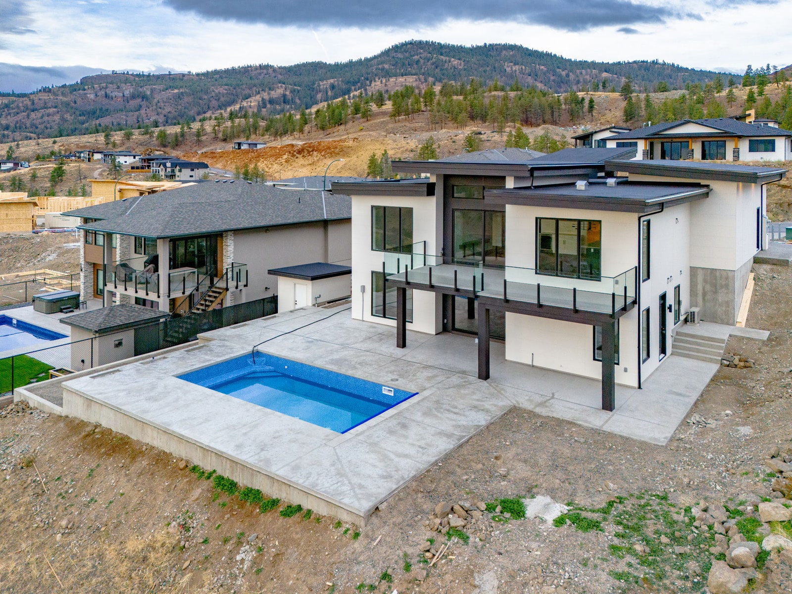 A contemporary home featuring a swimming pool and scenic views of surrounding mountains.