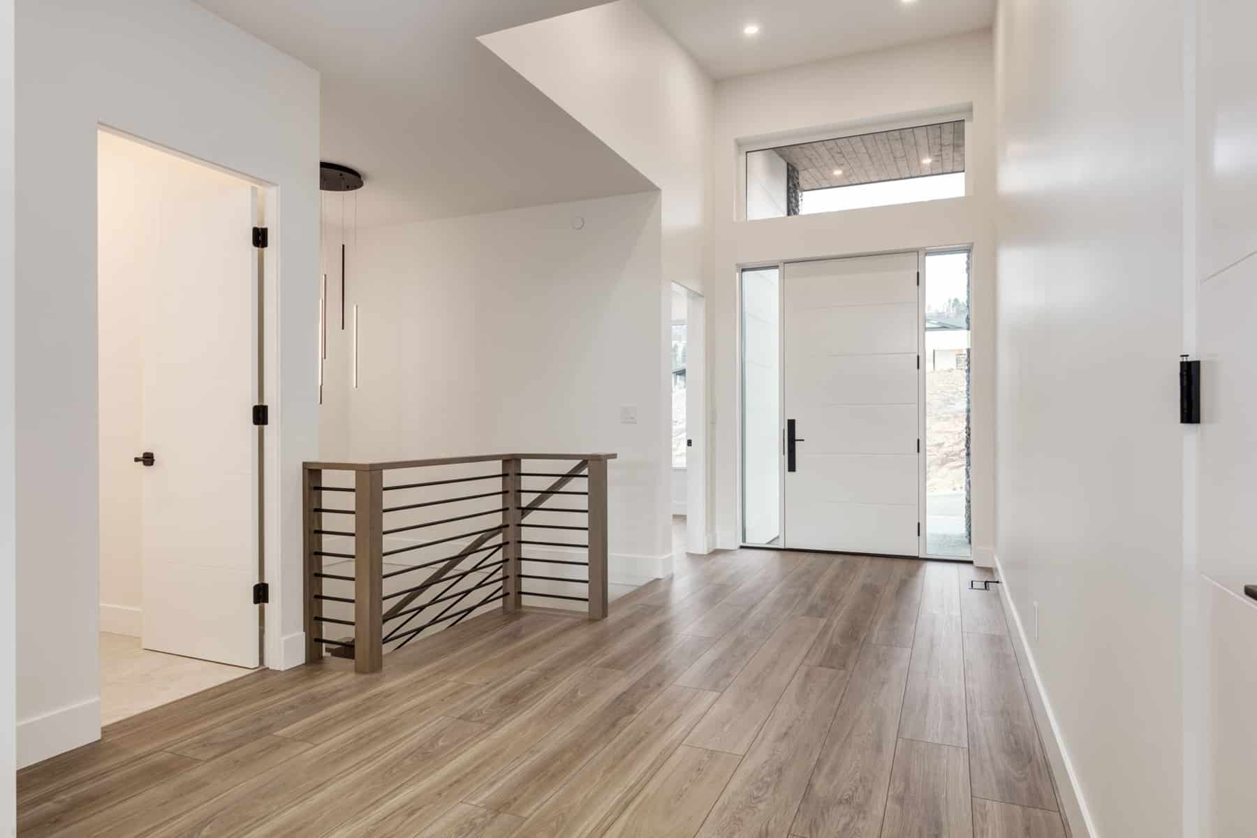 A hallway featuring white walls and polished wooden floors, creating a bright and inviting atmosphere.