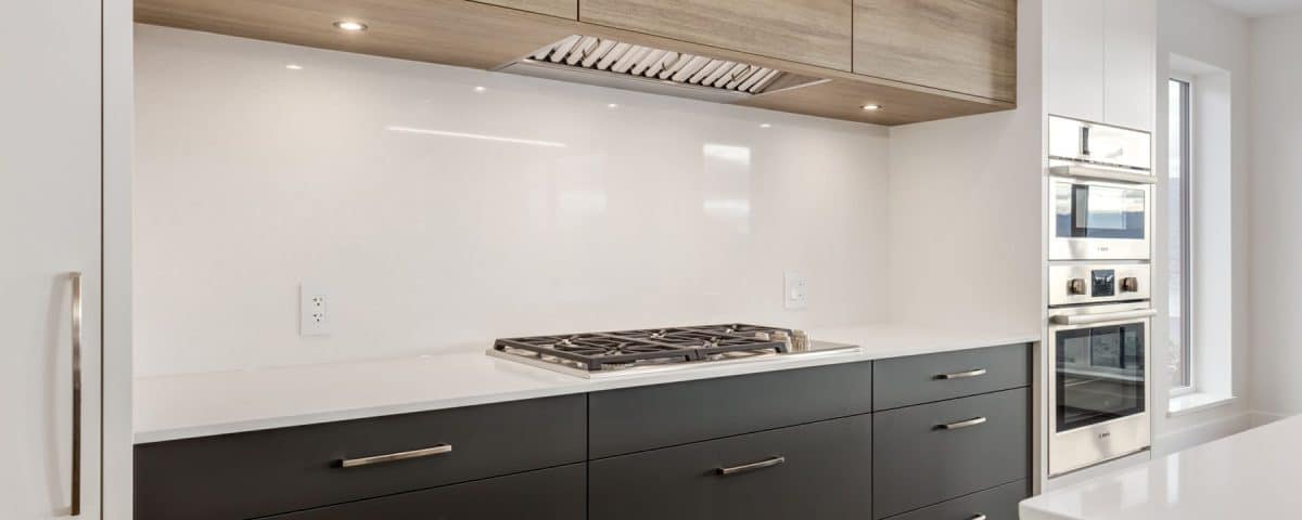 A modern kitchen featuring white cabinets and warm wood floors, creating a bright and inviting atmosphere