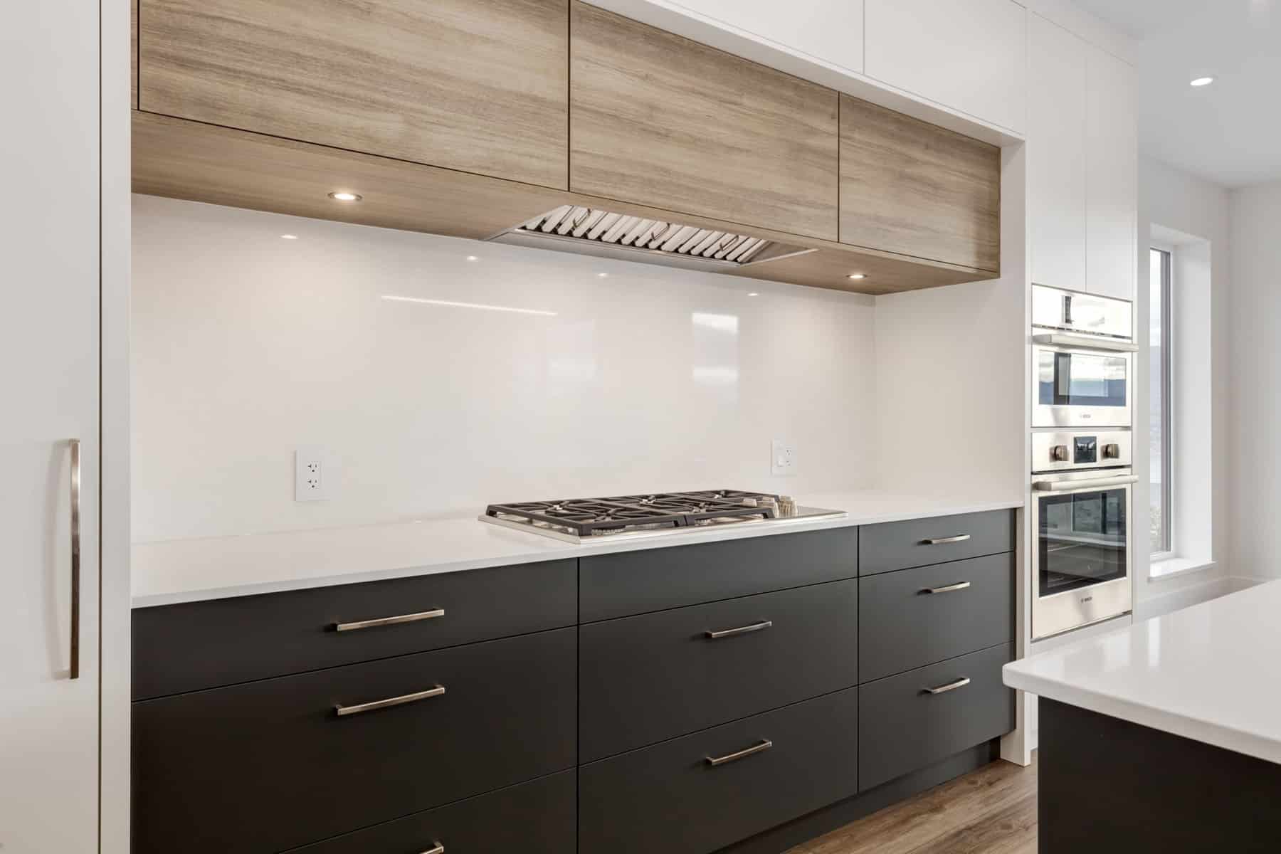A modern kitchen featuring white cabinets and warm wood floors, creating a bright and inviting atmosphere