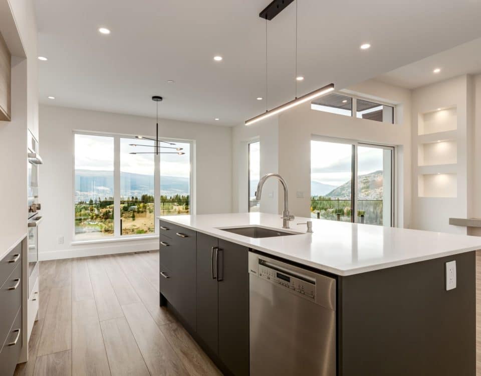 A modern kitchen featuring stainless steel appliances and a scenic view of the mountains through a large window.