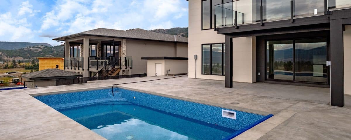 A modern home featuring a pool and a balcony, showcasing contemporary architecture and outdoor living space.