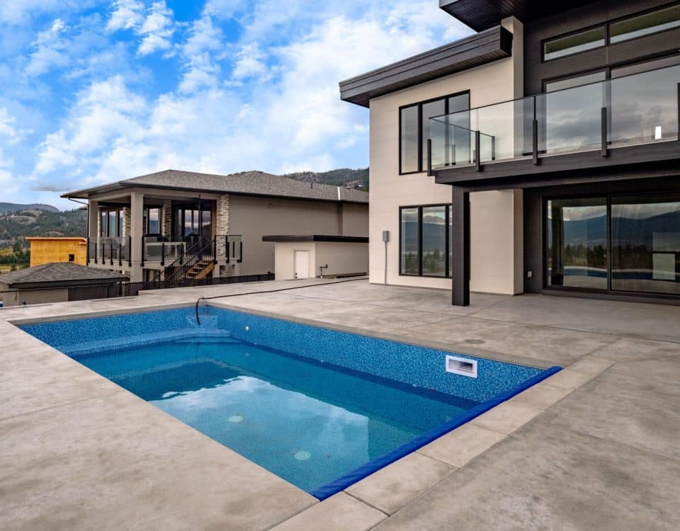 A modern home featuring a pool and a balcony, showcasing contemporary architecture and outdoor living space.