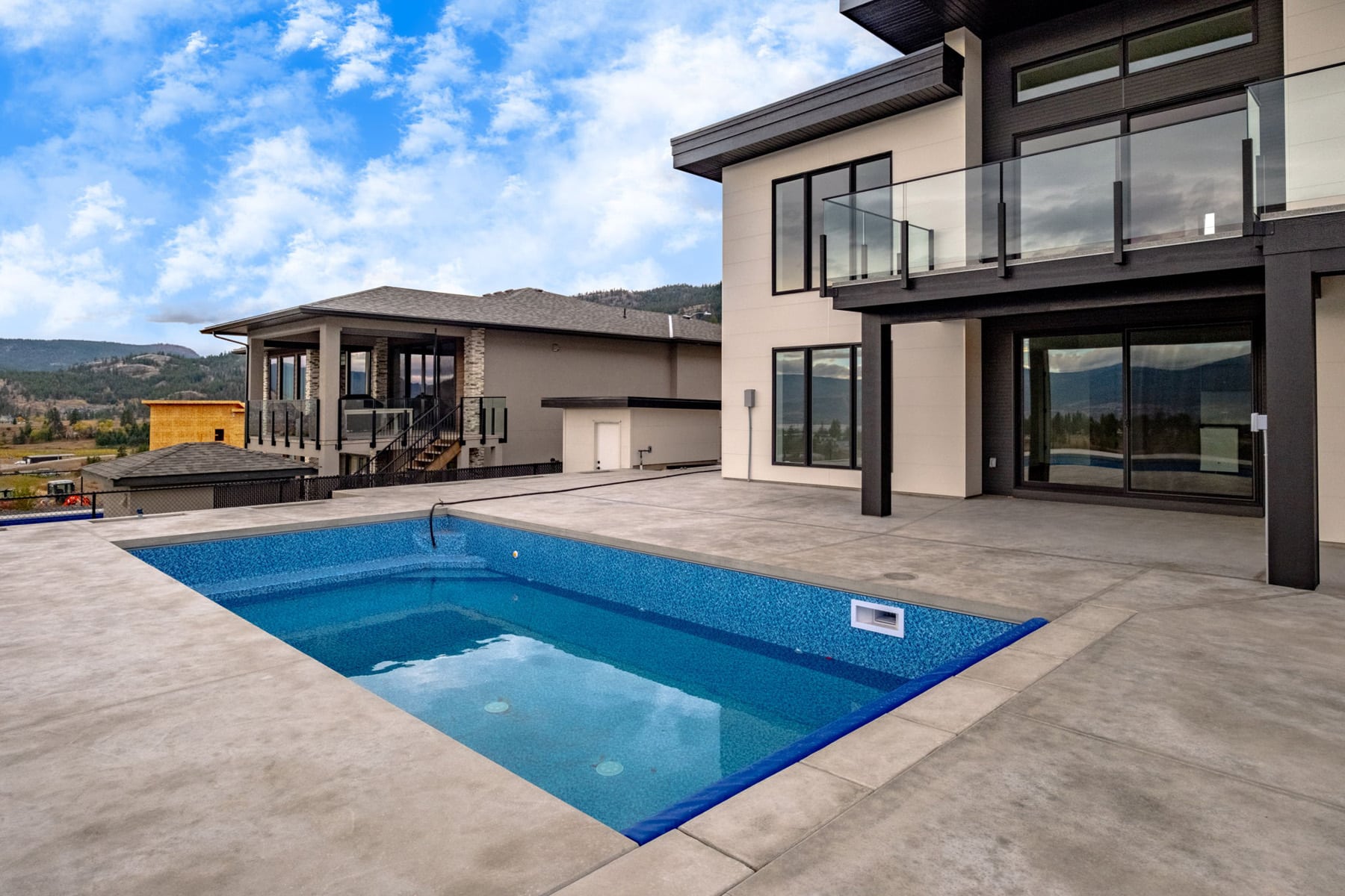 A modern home featuring a pool and a balcony, showcasing contemporary architecture and outdoor living space.