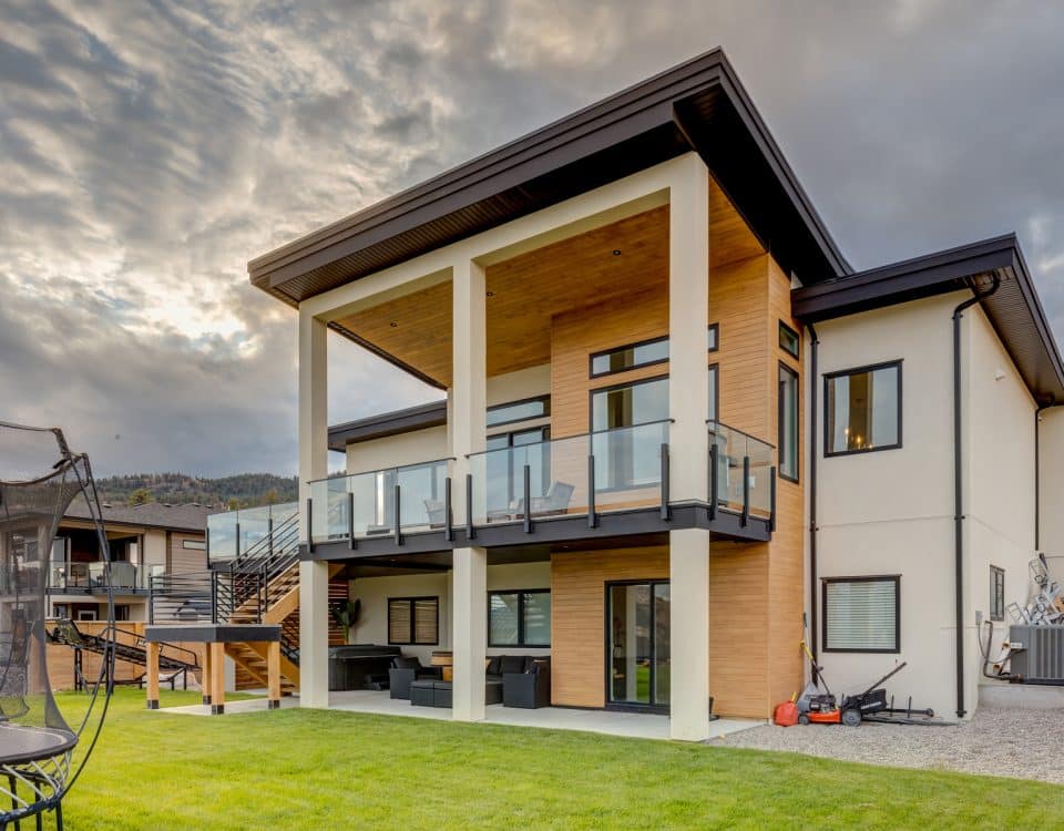 A modern home featuring a spacious deck and a large yard, showcasing contemporary architecture and outdoor living space.