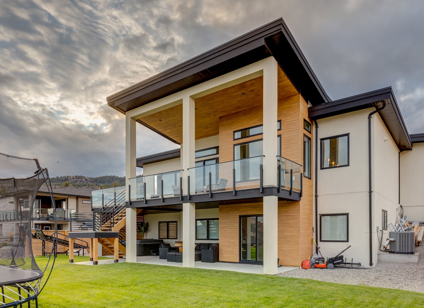 A modern home featuring a spacious deck and a large yard, showcasing contemporary architecture and outdoor living space.