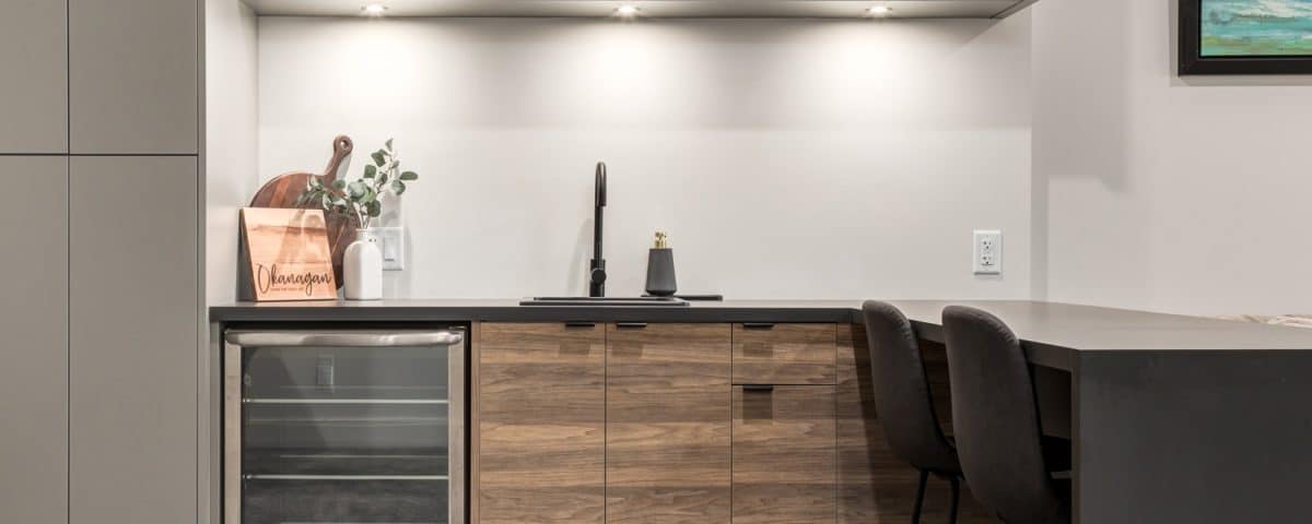 A modern kitchen featuring a wine cooler and stylish bar stools, creating an inviting space for dining and entertaining.