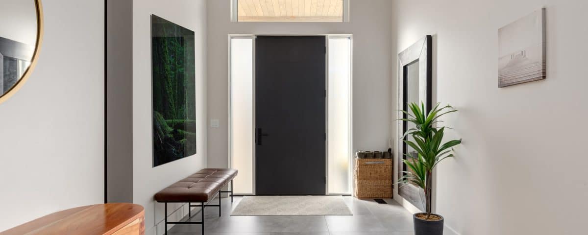 A hallway featuring a polished wooden floor and a large mirror reflecting the space.
