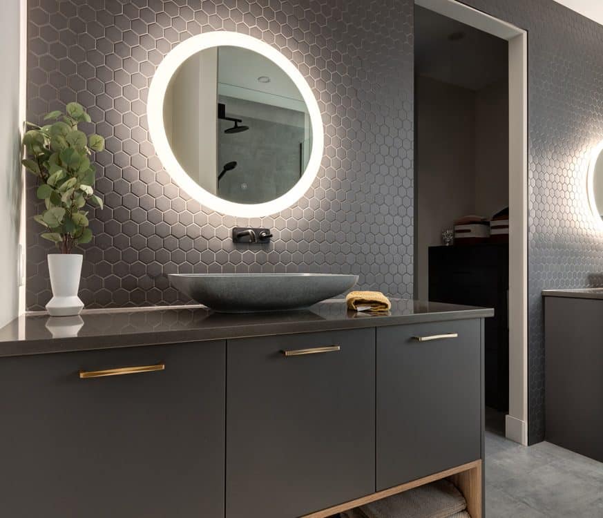 A modern bathroom featuring a large mirror above a sleek sink, showcasing contemporary design elements and clean lines.