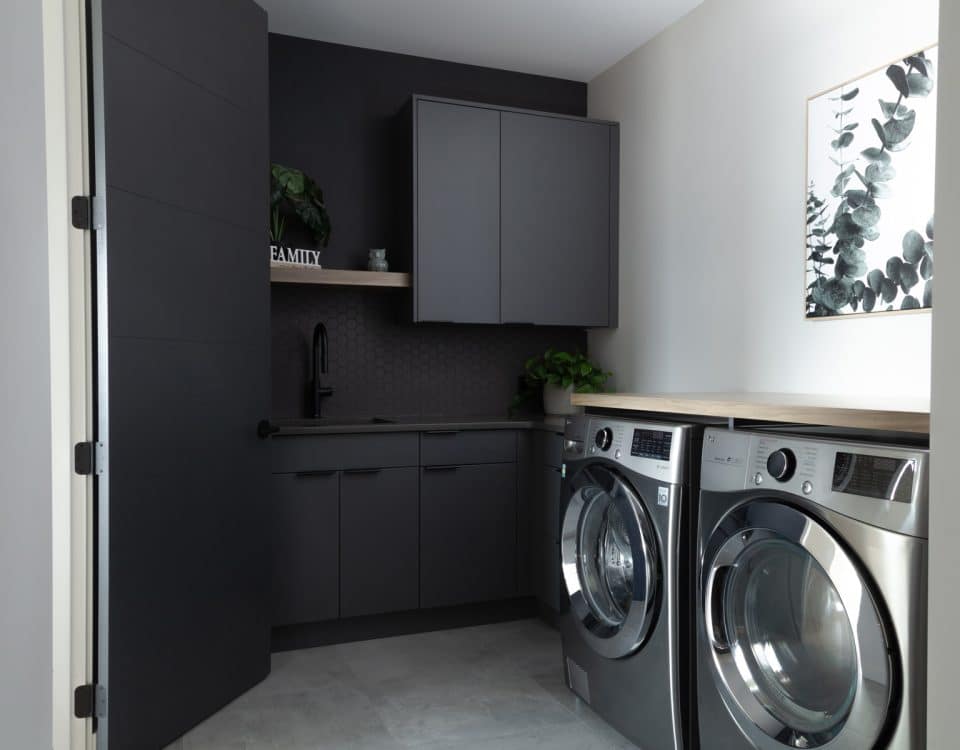 A modern laundry room featuring a sleek washer and dryer, with organized shelves and bright lighting for a clean look.