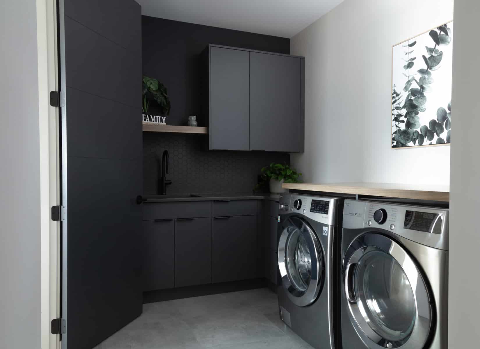 A modern laundry room featuring a sleek washer and dryer, with organized shelves and bright lighting for a clean look.