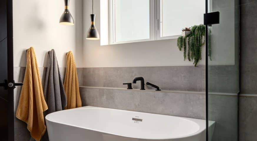 A modern bathroom featuring a spacious bathtub and a sleek shower, showcasing contemporary design elements.