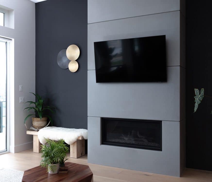 A contemporary living room featuring a black accent wall and a flat-screen TV mounted above a stylish media console.