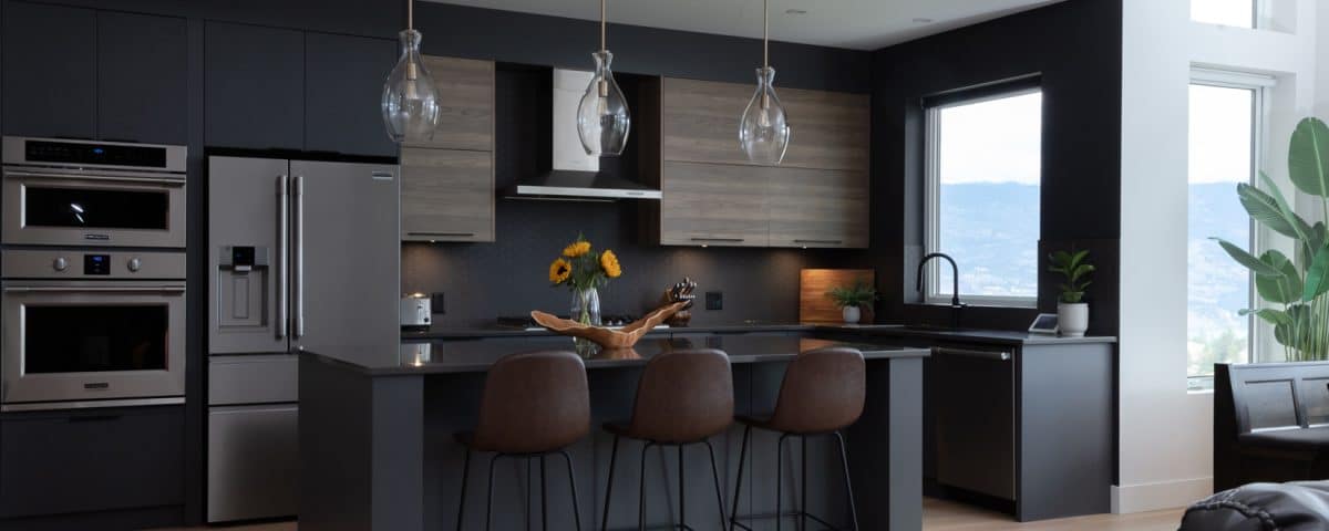 A modern kitchen featuring dark wood floors and sleek black cabinets, creating a stylish and contemporary atmosphere.