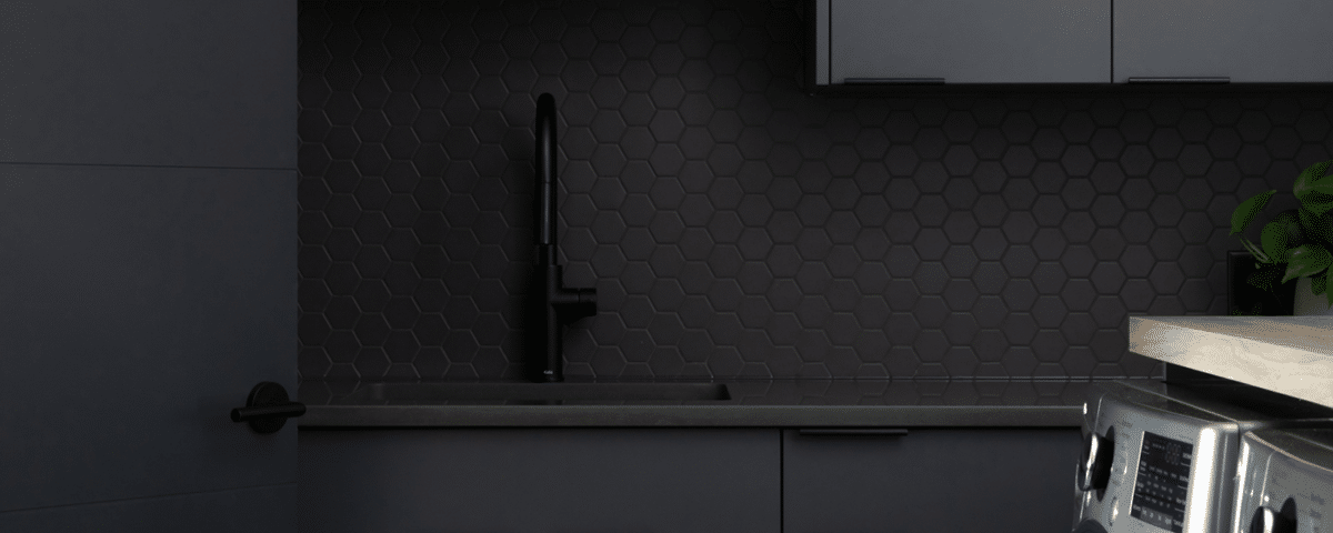 A modern laundry room featuring sleek black cabinets and a washing machine, showcasing a stylish and functional design.
