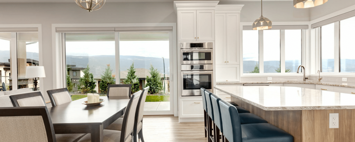 A modern kitchen featuring a dining table surrounded by chairs, showcasing a warm and inviting atmosphere.