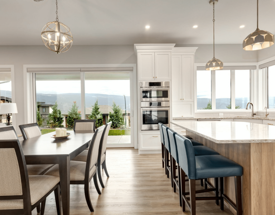 A modern kitchen featuring a dining table surrounded by chairs, showcasing a warm and inviting atmosphere.