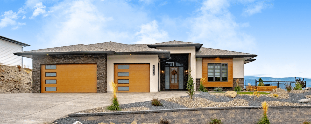 A residential home featuring a garage and a paved driveway leading up to the entrance.