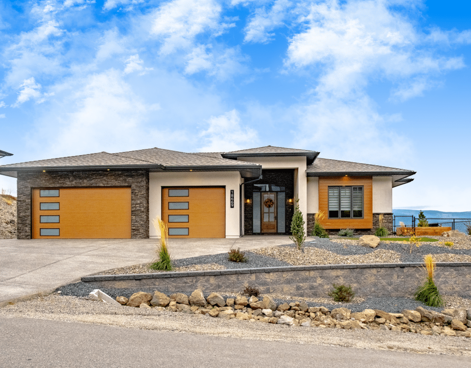 A residential home featuring a garage and a paved driveway leading up to the entrance.
