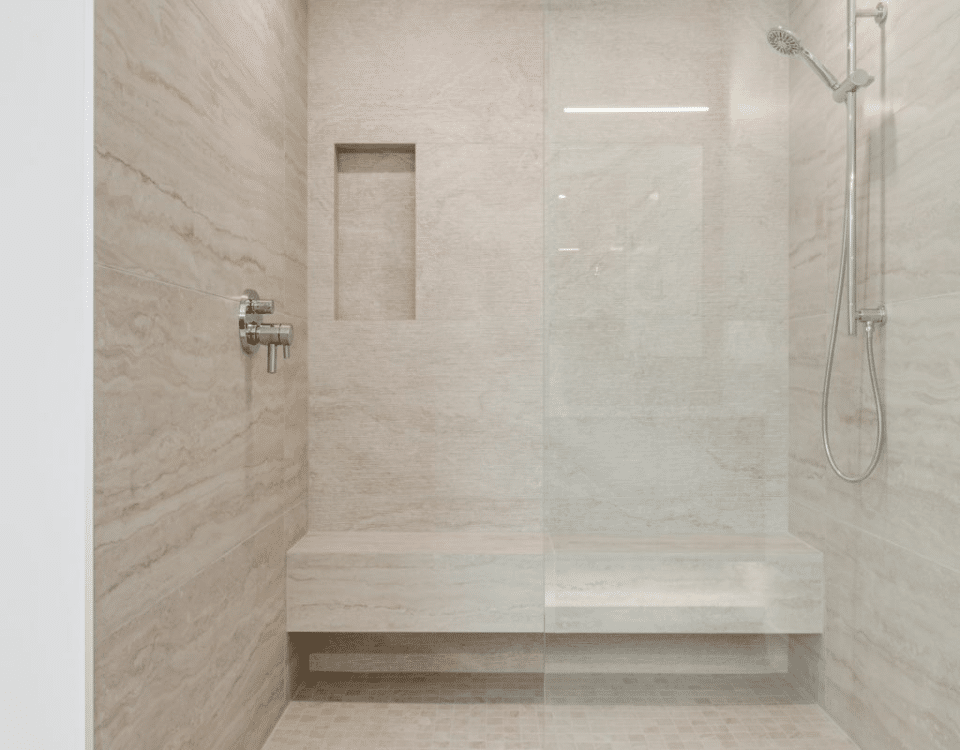 A spacious walk-in shower featuring a sleek glass door, showcasing modern design and ample room for comfort.