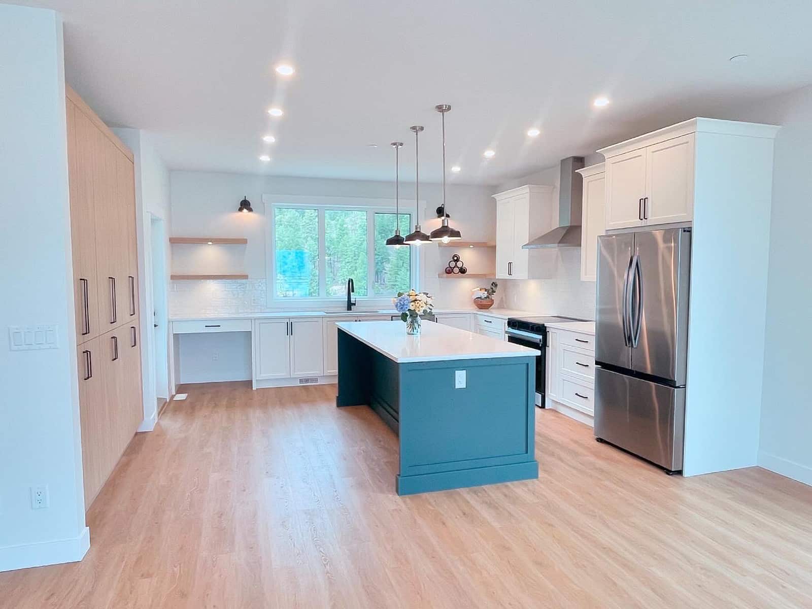 A clean kitchen featuring white cabinets and blue countertops, showcasing a modern and inviting design.