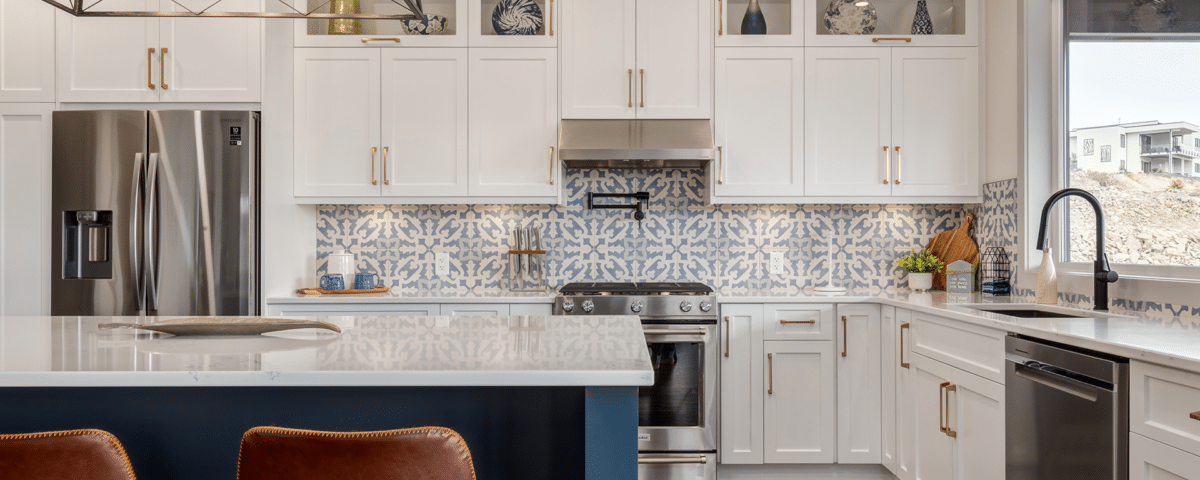 A modern kitchen featuring blue and white cabinets with a spacious center island for cooking and dining.