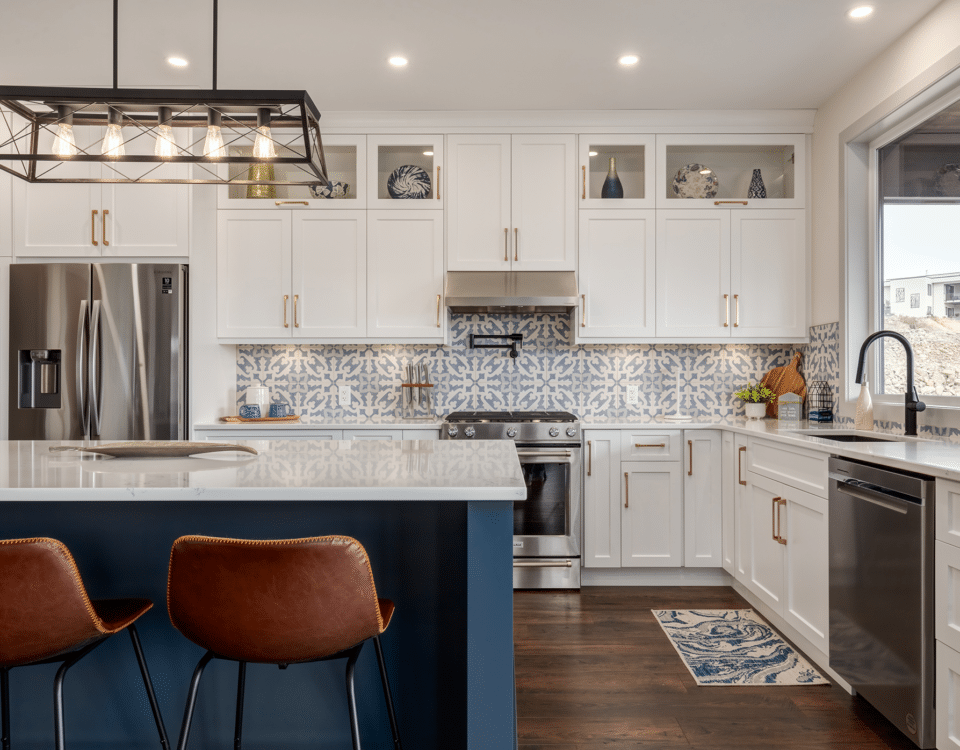 A modern kitchen featuring blue and white cabinets with a spacious center island for cooking and dining.