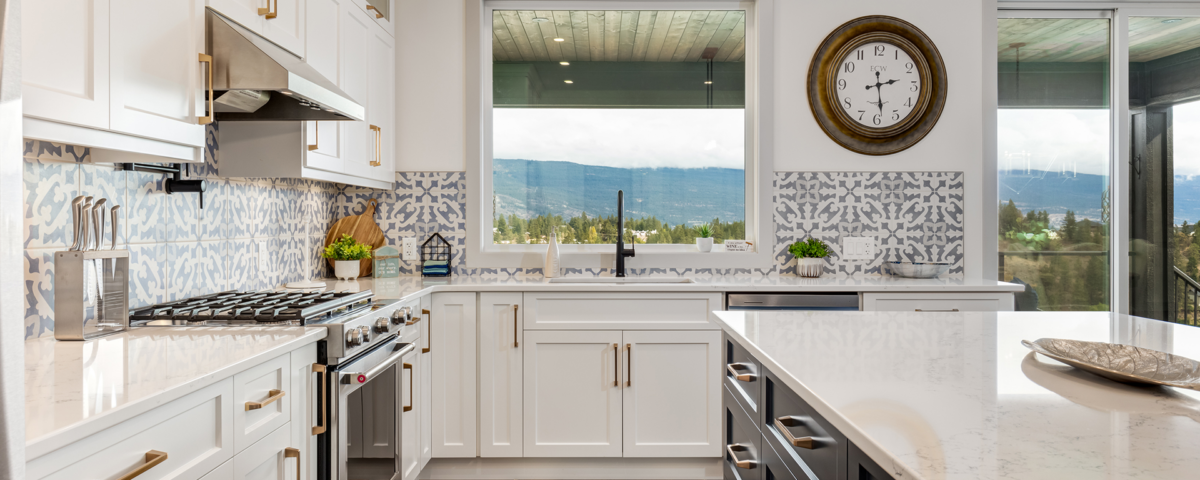 A modern kitchen featuring a spacious island and a wall clock, showcasing a bright and inviting atmosphere.