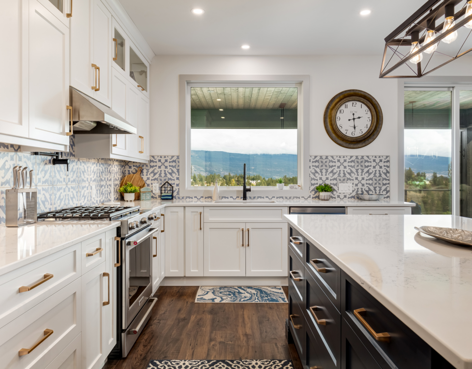 A modern kitchen featuring a spacious island and a wall clock, showcasing a bright and inviting atmosphere.