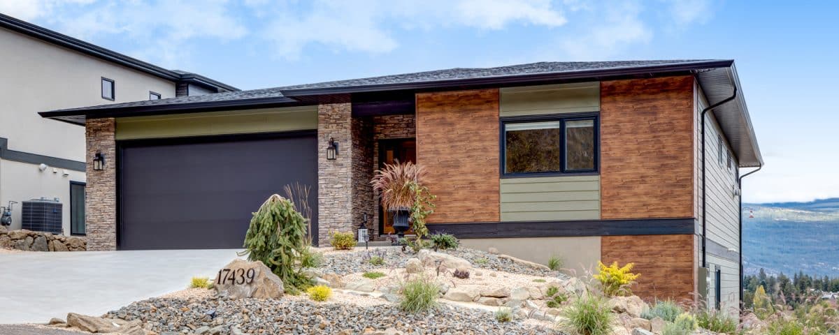 A modern home featuring a driveway and an attached garage, showcasing contemporary architectural design.