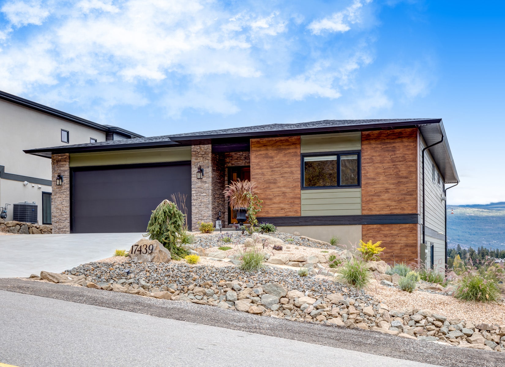 A modern home featuring a driveway and an attached garage, showcasing contemporary architectural design.