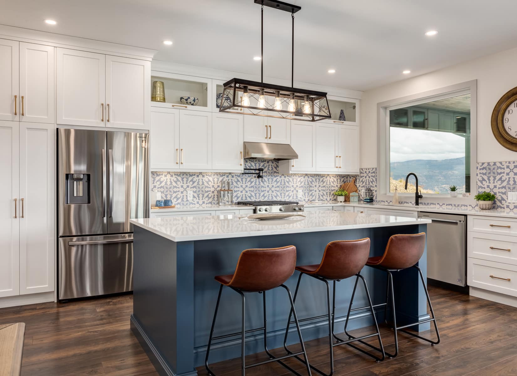 A modern kitchen featuring blue and white cabinets with a spacious center island for cooking and dining.