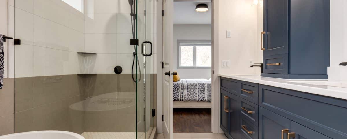 A modern bathroom featuring blue cabinets and a spacious walk-in shower.