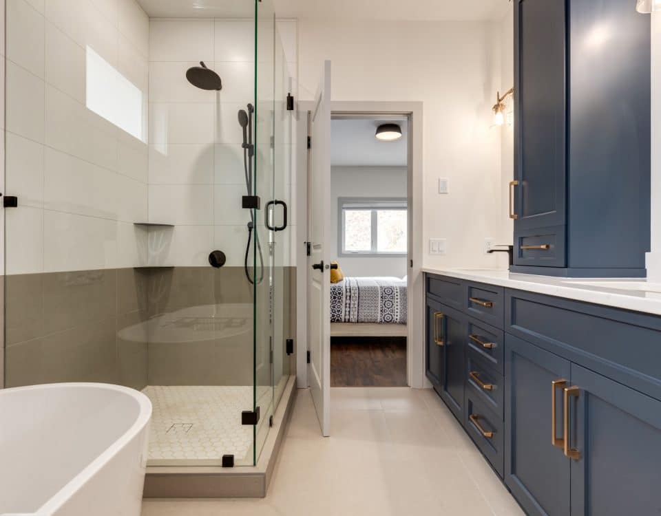 A modern bathroom featuring blue cabinets and a spacious walk-in shower.