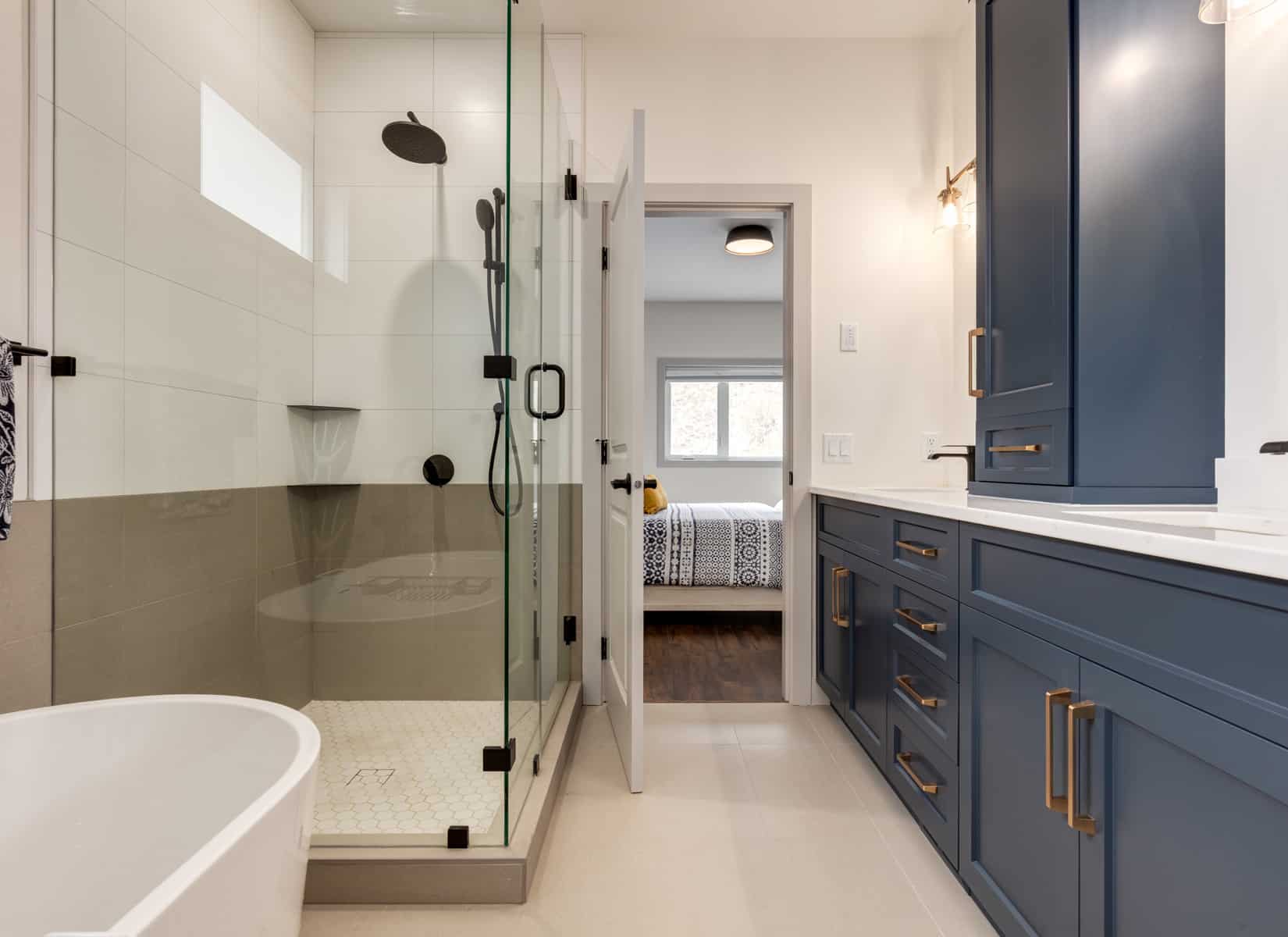 A modern bathroom featuring blue cabinets and a spacious walk-in shower.