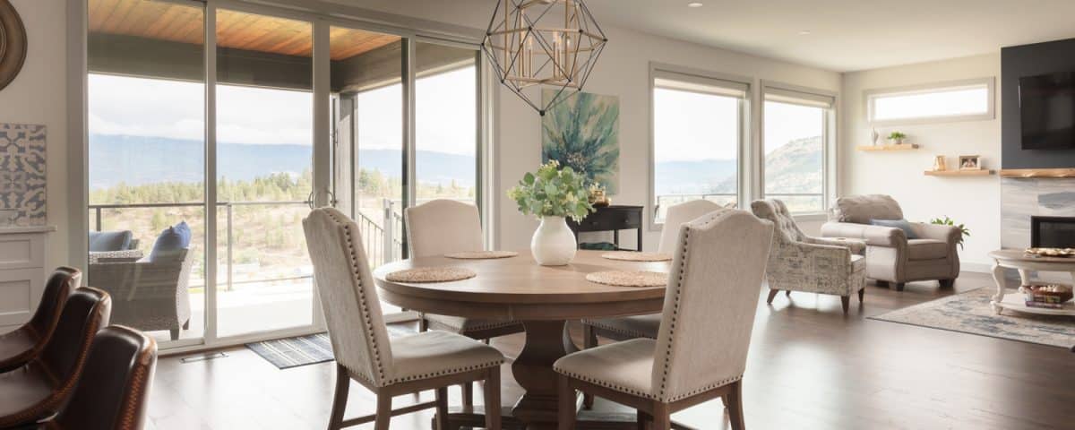 A dining room featuring a wooden table surrounded by four chairs, with soft lighting and decorative elements.