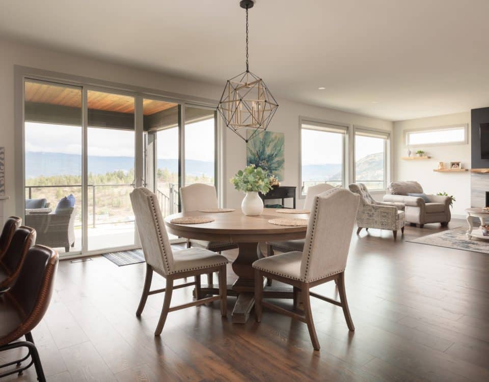 A dining room featuring a wooden table surrounded by four chairs, with soft lighting and decorative elements.