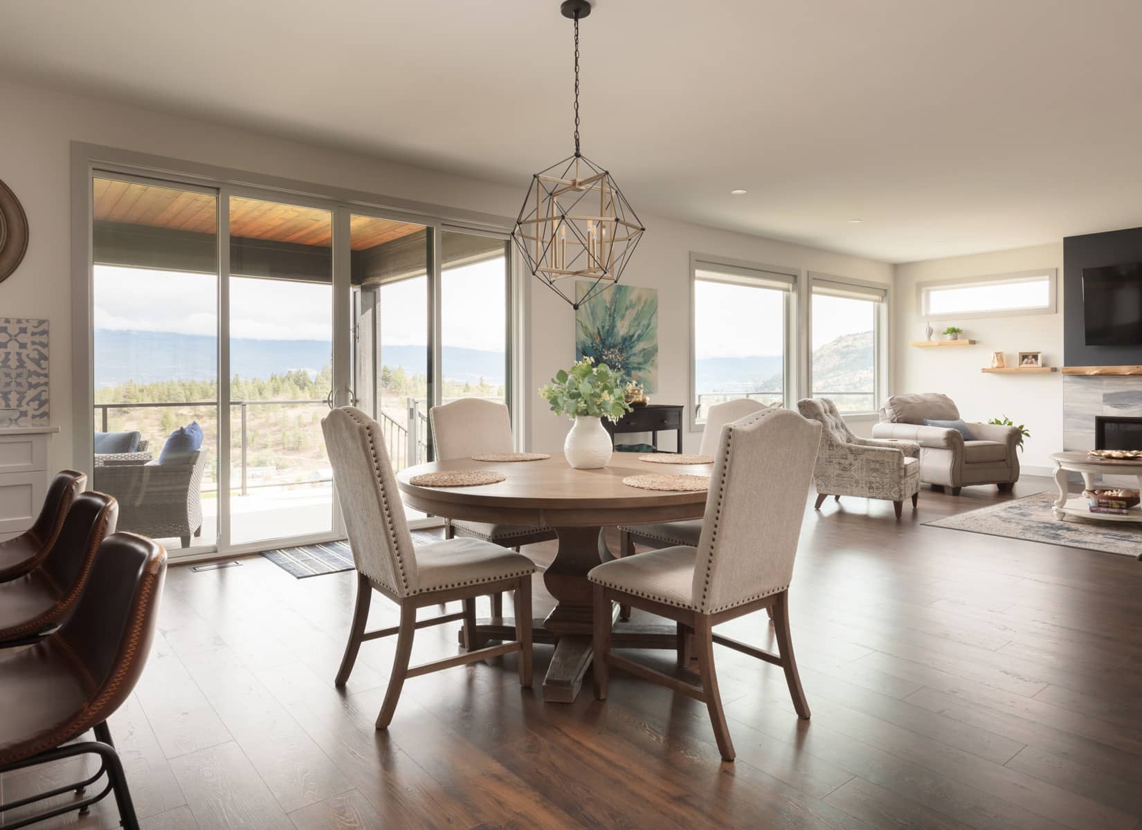 A dining room featuring a wooden table surrounded by four chairs, with soft lighting and decorative elements.
